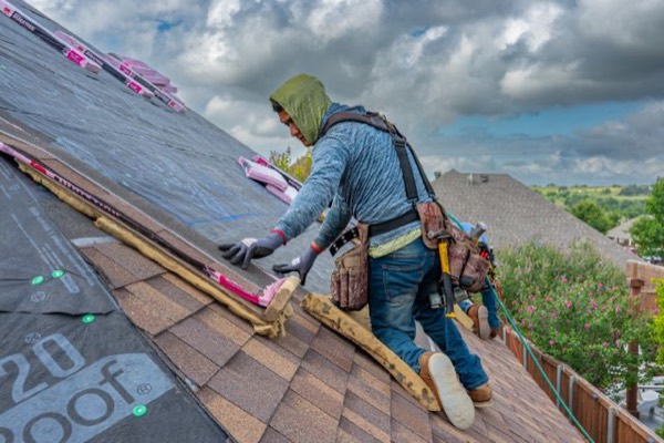 Roofers installing shingles